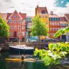 Kvinne i kayakk forbi fargerike kanaler i Christianshavn